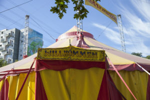 gelb/rotes Zirkuszelt mit Willkommens-Schild am Eingang