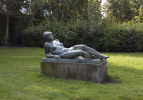 Stein-Skulptur "liegende Frau, die ihre Beine verschränkt"