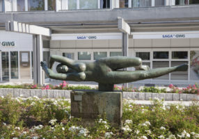 Stein-Skulptur "schräg liegende Frau, die ihre Arme verschränkt"