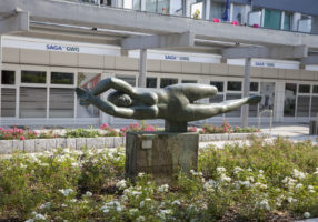 Stein-Skulptur "schräg liegende Frau, die ihre Arme verschränkt"