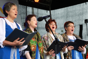 4 Frauen halten ein Gesangsbuch in der Hand und singen