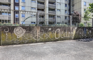Reserve Graffiti an einer langen Wand. Zu sehen ist ein Smiley als Astronaut und in Schnörkelschrift steht dort Osdorf geschrieben
