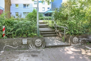 Reserve Graffiti rechts und links an einer Wand, in der Mitte geht eine Treppe hoch. Zu sehen sind 2 Smiley, der eine streckt die Zunge raus, der andere trägt eine Brille