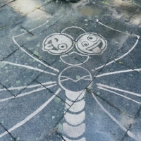 Reserve Graffiti Bild auf dem Boden. Zu sehen ist eine Libelle und 2 Smileys, die die Zunge raustrecken